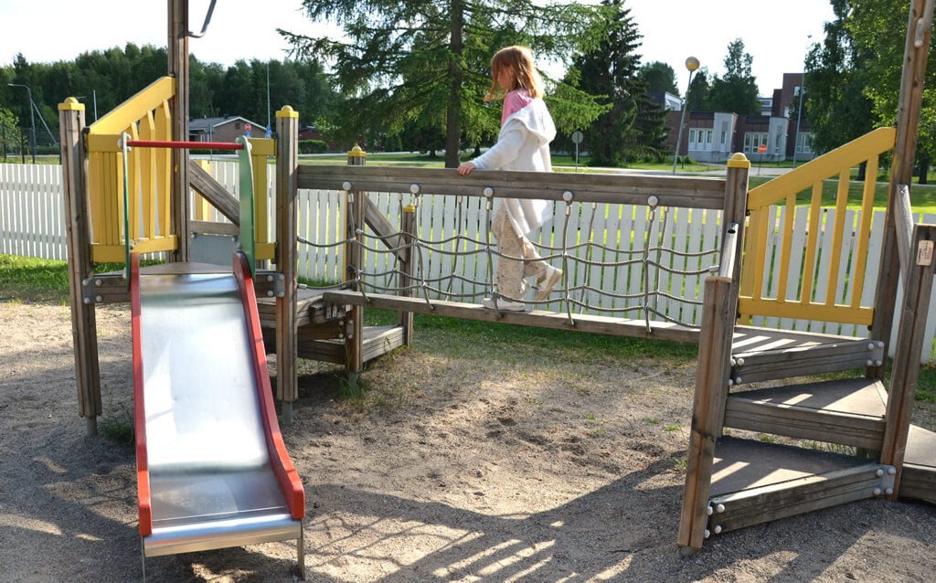 Lapsi kävelee kiipeilytelineen kävelysiltaa pitkin leikkikentällä.